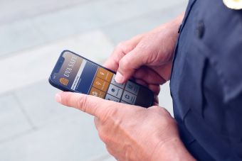 Chief Longo holds a mobile device showing the new safety app